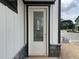 Entry door with glass and white trim surrounded by stone and white siding at 2400 Adrift Rd, Fuquay Varina, NC 27526