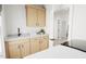 Laundry room with wood cabinets, grey countertops, and stainless steel sink at 2400 Adrift Rd, Fuquay Varina, NC 27526