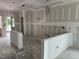 Open-concept living space with drywall, kitchen island, and bright windows at 2400 Adrift Rd, Fuquay Varina, NC 27526