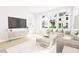 Inviting living room with large windows, light wood floors, and a stylish entertainment center at 2400 Adrift Rd, Fuquay Varina, NC 27526