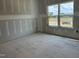 Bright room with a large window and unfinished walls, offering a blank canvas to create your dream space at 2400 Adrift Rd, Fuquay Varina, NC 27526