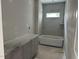 Bathroom features a tub and tiled walls and a window, showcasing a modern design at 2404 Adrift Rd, Fuquay Varina, NC 27526