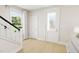 Bright foyer features hardwood floors, a staircase with white railings, a large window, and doors for ample natural light at 2404 Adrift Rd, Fuquay Varina, NC 27526