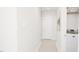 Hallway featuring neutral colored floors and wall paint, doors, and nearby laundry room at 2404 Adrift Rd, Fuquay Varina, NC 27526