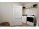 Modern laundry room with a washer, dryer, and shelving with baskets and towels at 2404 Adrift Rd, Fuquay Varina, NC 27526