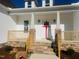 Front entrance with stone steps, red bow, and white columns at 119 Seahawk Way, Zebulon, NC 27597