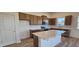 Modern kitchen featuring wood cabinets, stainless steel appliances, a subway tile backsplash, and an island at 159 Robert Howe Dr, Fuquay Varina, NC 27526