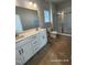 Bathroom featuring a double vanity, large mirror, and walk-in shower with glass doors at 210 Drayton Hall Ln, Sanford, NC 27330