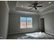 Bedroom featuring a tray ceiling, large window, neutral paint, and plush carpeting at 210 Drayton Hall Ln, Sanford, NC 27330