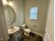 Half bathroom with a pedestal sink, tiled floor, and natural light from a window at 315 Bishop Ln, Sanford, NC 27330