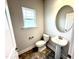 A bathroom with a toilet, sink, and an oval mirror at 315 Bishop Ln, Sanford, NC 27330