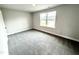 Bright bedroom featuring neutral walls, carpet, and natural light from a large window at 315 Bishop Ln, Sanford, NC 27330
