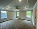 Spacious main bedroom with a tray ceiling, ceiling fan, and three windows for natural light at 315 Bishop Ln, Sanford, NC 27330