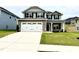 Charming two-story home featuring a spacious driveway and a manicured lawn with stone accents on the facade at 324 Bishop Ln, Sanford, NC 27330