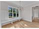 Sunlit dining area with hardwood floors, built-in bench seating and modern light fixture at 113 S Ennis St, Fuquay Varina, NC 27526