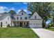 Charming two-story modern farmhouse with a two-car garage, covered porch, and lush lawn at 113 S Ennis St, Fuquay Varina, NC 27526