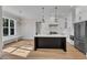 Spacious kitchen with white cabinets, black island, stainless steel appliances and hardwood floors at 113 S Ennis St, Fuquay Varina, NC 27526