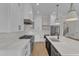 Bright kitchen features white cabinets, a black island, stainless steel appliances, and hardwood floors at 113 S Ennis St, Fuquay Varina, NC 27526