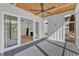 Relaxing screened porch featuring a ceiling fan, gray wood flooring, and access to the interior living area at 113 S Ennis St, Fuquay Varina, NC 27526