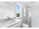 Bright bathroom featuring a large sink, toilet, and glass-enclosed shower with natural light from the window at 929 Kinglet House Rd, Knightdale, NC 27545