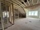 Unfinished attic space featuring wood framing, spray foam insulation, and natural light from windows at 7000 North Ridge Dr, Raleigh, NC 27615