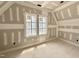 Well-lit room with large windows showing the trim, drywall, and ceiling work in progress at 7000 North Ridge Dr, Raleigh, NC 27615