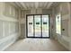 Bright bedroom with sliding door to the exterior with views of the backyard and a side window at 7000 North Ridge Dr, Raleigh, NC 27615