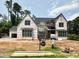 Stunning new construction home featuring a modern design with black windows and a light-colored facade at 7000 North Ridge Dr, Raleigh, NC 27615