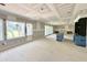 Unfinished living room with large windows and sliding glass doors to outdoor space at 7000 North Ridge Dr, Raleigh, NC 27615