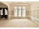 Bright, unfinished living room with large windows and an arched doorway at 7000 North Ridge Dr, Raleigh, NC 27615