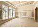 Unfinished living room featuring tray ceiling, large windows, and arched doorway at 7000 North Ridge Dr, Raleigh, NC 27615