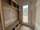 Mudroom with built-in shelving, bench, and a door leading to the outside at 7000 North Ridge Dr, Raleigh, NC 27615