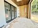 Covered patio with wood ceiling, large black framed windows and exterior view of the natural surroundings at 7000 North Ridge Dr, Raleigh, NC 27615