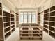 Large walk-in closet with custom shelving and storage solutions, and a bright window at 7000 North Ridge Dr, Raleigh, NC 27615