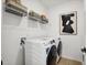 Bright laundry room with washer, dryer, and ample shelving at 125 S Stone Mill Trl # 241, Clayton, NC 27520