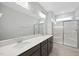 A clean modern bathroom with a double vanity, quartz countertop, and glass enclosed shower at 28 Nettle Ln # 235, Clayton, NC 27520