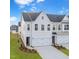 New construction townhome with white siding, black roof, two car garage, and a manicured lawn at 28 Nettle Ln # 235, Clayton, NC 27520