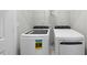 New white washer and dryer set in a bright laundry room with overhead wire shelving at 28 Nettle Ln # 235, Clayton, NC 27520