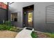 Modern home's front entrance featuring a glass door, clean lines, and professional landscaping at 1511 Malta Ave, Raleigh, NC 27610