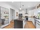 A bright kitchen featuring an island with seating, stainless steel appliances, and modern lighting at 1511 Malta Ave, Raleigh, NC 27610