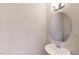 Modern half-bathroom featuring a pedestal sink, oval mirror, and sleek fixtures at 3181 Mission Olive Pl # 346, New Hill, NC 27562