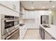 Sleek kitchen featuring stainless steel appliances, white cabinets, an island, and modern finishes at 3181 Mission Olive Pl # 346, New Hill, NC 27562