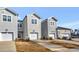 Rear view of townhomes featuring attached garages and landscaping at 3181 Mission Olive Pl # 346, New Hill, NC 27562
