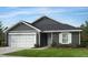 Charming home features gray siding, white trim, a two-car garage, and well-manicured landscaping at 222 Chestnut Oak Ln, Lillington, NC 27546