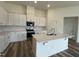 Modern kitchen with stainless steel appliances, white cabinets and an island, enhancing both style and functionality at 222 Chestnut Oak Ln, Lillington, NC 27546