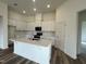Bright kitchen with stainless steel appliances, white cabinets and an island, enhancing both style and functionality at 222 Chestnut Oak Ln, Lillington, NC 27546