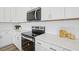 Close-up of a well-equipped kitchen with sleek appliances, white cabinetry, and stylish backsplash at 222 Chestnut Oak Ln, Lillington, NC 27546