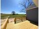 Spacious new wooden deck with views of a large grassy field on a sunny day at 1681 S Old Carriage Rd, Rocky Mount, NC 27804