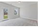 Bright bedroom with neutral carpet, a window, and a glass door leading to an outdoor space at 2038 Fishamble St, Fuquay Varina, NC 27526