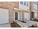 Close up of modern townhome exterior with brick accents, a gray front door, and an attached white garage at 2038 Fishamble St, Fuquay Varina, NC 27526